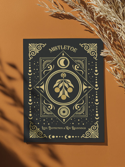 Mistletoe-themed holiday ritual card featuring a gold-stylized mistletoe design with celestial and ornate decorative accents on the front and an inside message explaining the mistletoe's historical significance and its use in Winter Solstice and Twelfth Night rituals for love, protection, and prosperity.